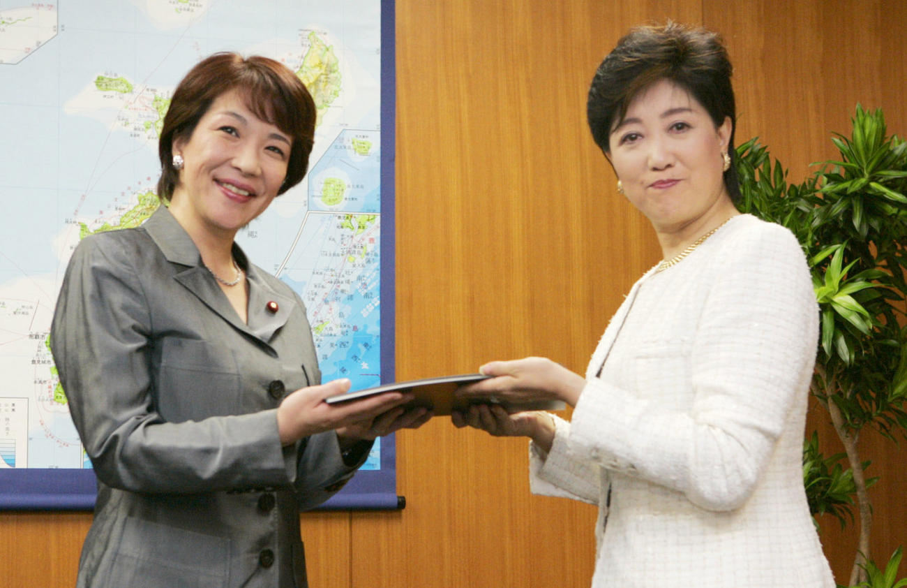 2006年9月、小池前沖縄北方担当相（右）から引き継ぎを受ける高市沖縄北方担当相（共同）