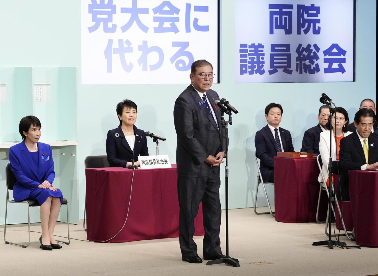 自民党総裁選後に開かれた両院議員総会であいさつする石破首相。左端は高市早苗新総裁（共同）