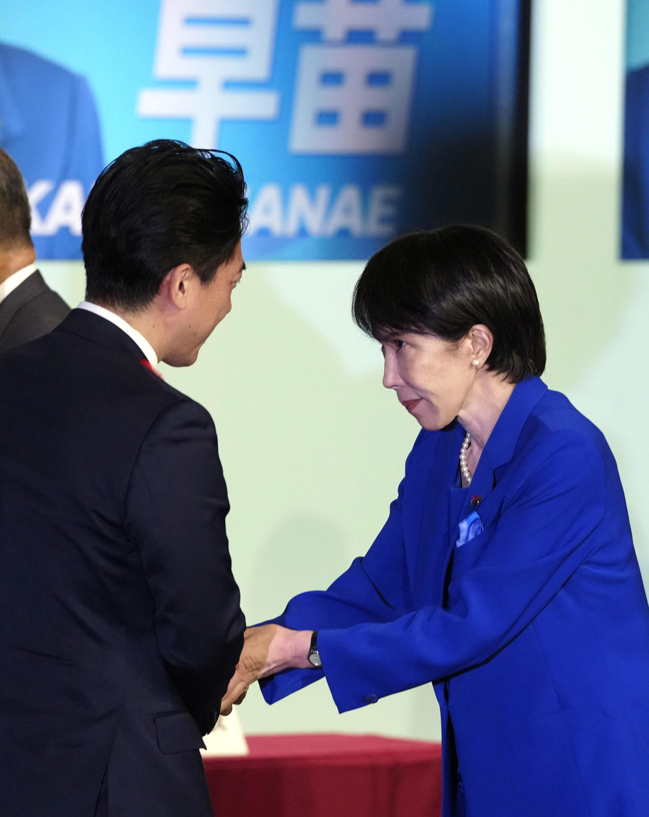 自民党総裁選後に開かれた両院議員総会を終え、小泉進次郎氏（左）と握手する高市早苗新総裁（共同）