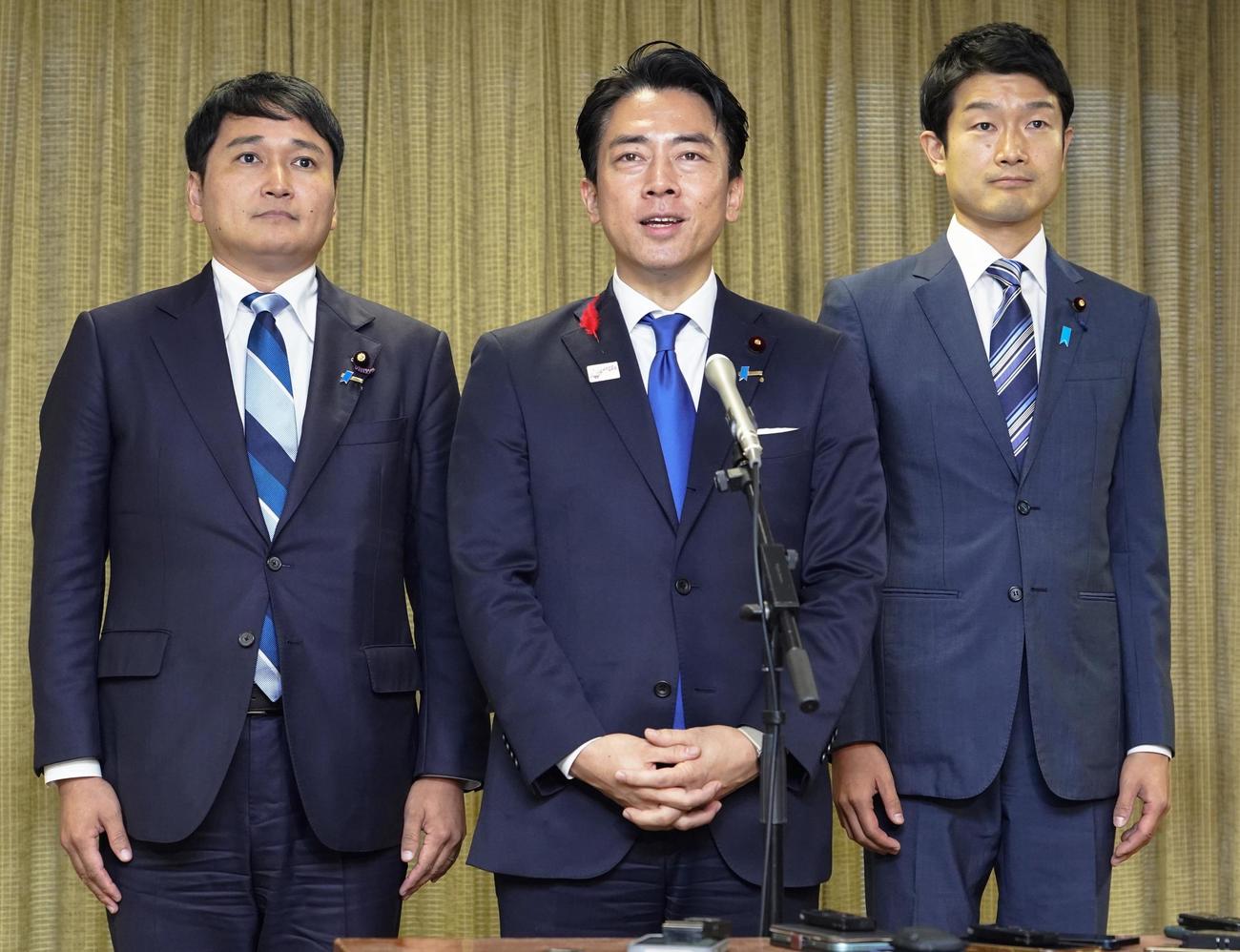 自民党総裁選の結果を受け、記者団の取材に応じる小泉進次郎氏（中央、共同）