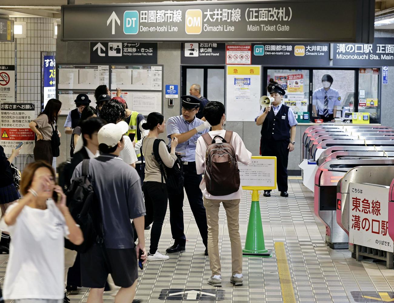 東急田園都市線溝の口駅で、駅員から振り替え輸送についての説明を受ける人たち＝6日午前7時20分、川崎市高津区（共同）