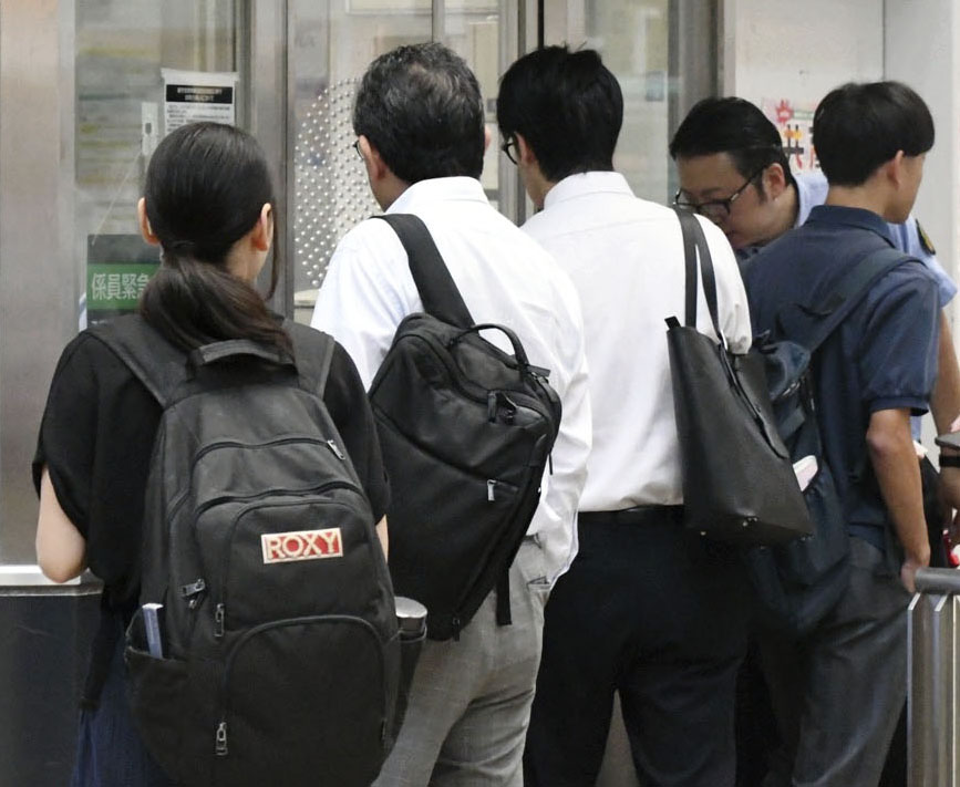 東急田園都市線たまプラーザ駅で、遅延状況を聞く人たち＝6日午前、横浜市青葉区（共同）
