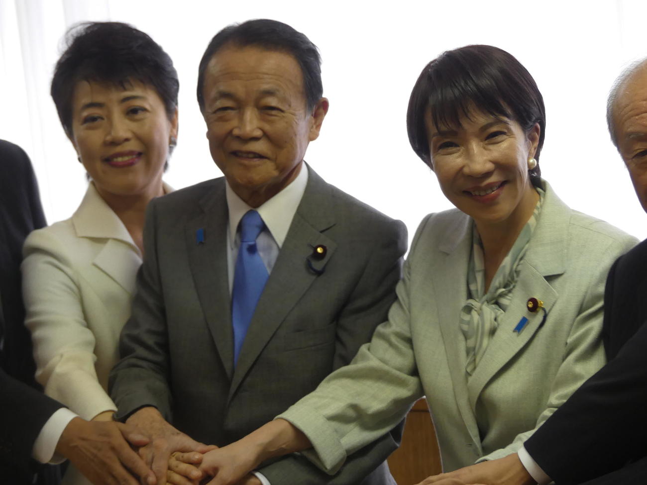 臨時総務会後、笑顔で手を重ねる麻生太郎副総裁（左から2人目）と高市早苗総裁（撮影中山知子）