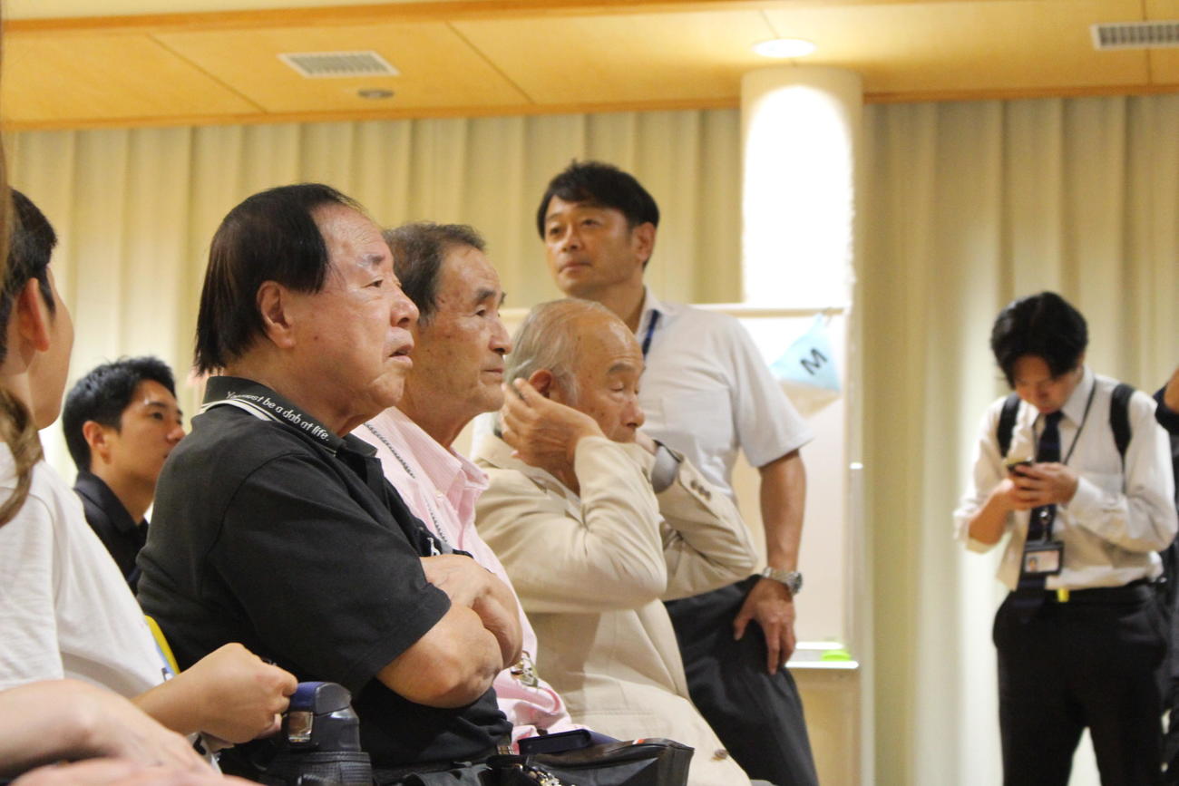 村上春樹さんの母校に集まり、現地からのライブ映像を見守っていたが…。手前から頭井さん。その右は内堀さん