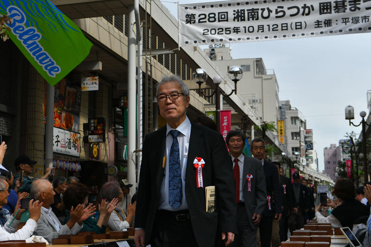 平塚駅前の目抜き通りを行進して開会式上へと入場する24世本因坊秀芳（石田芳夫九段）