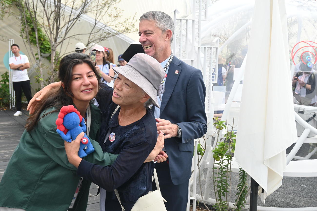 万博最終日、スイス館のスタッフに抱擁される山田外美代さん（撮影・松浦隆司）