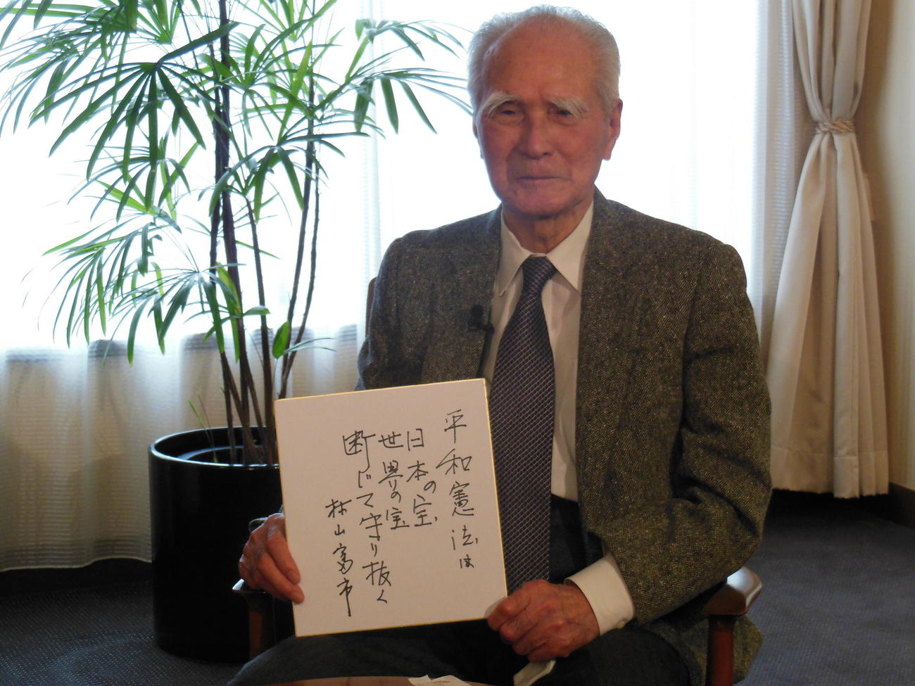 色紙を掲げる村山富市元首相（15年11月18日）