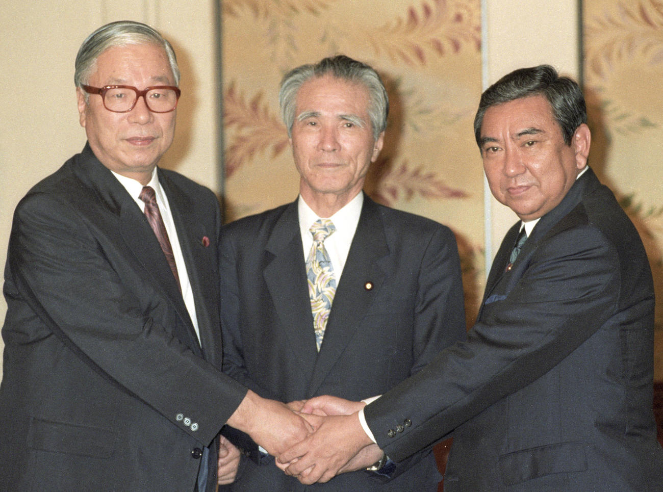 1994年6月、連立政権・組閣についての党首会談前に、新党さきがけの武村正義代表（左）、自民党の河野洋平総裁（右）と握手を交わす村山富市首相＝国会（共同）