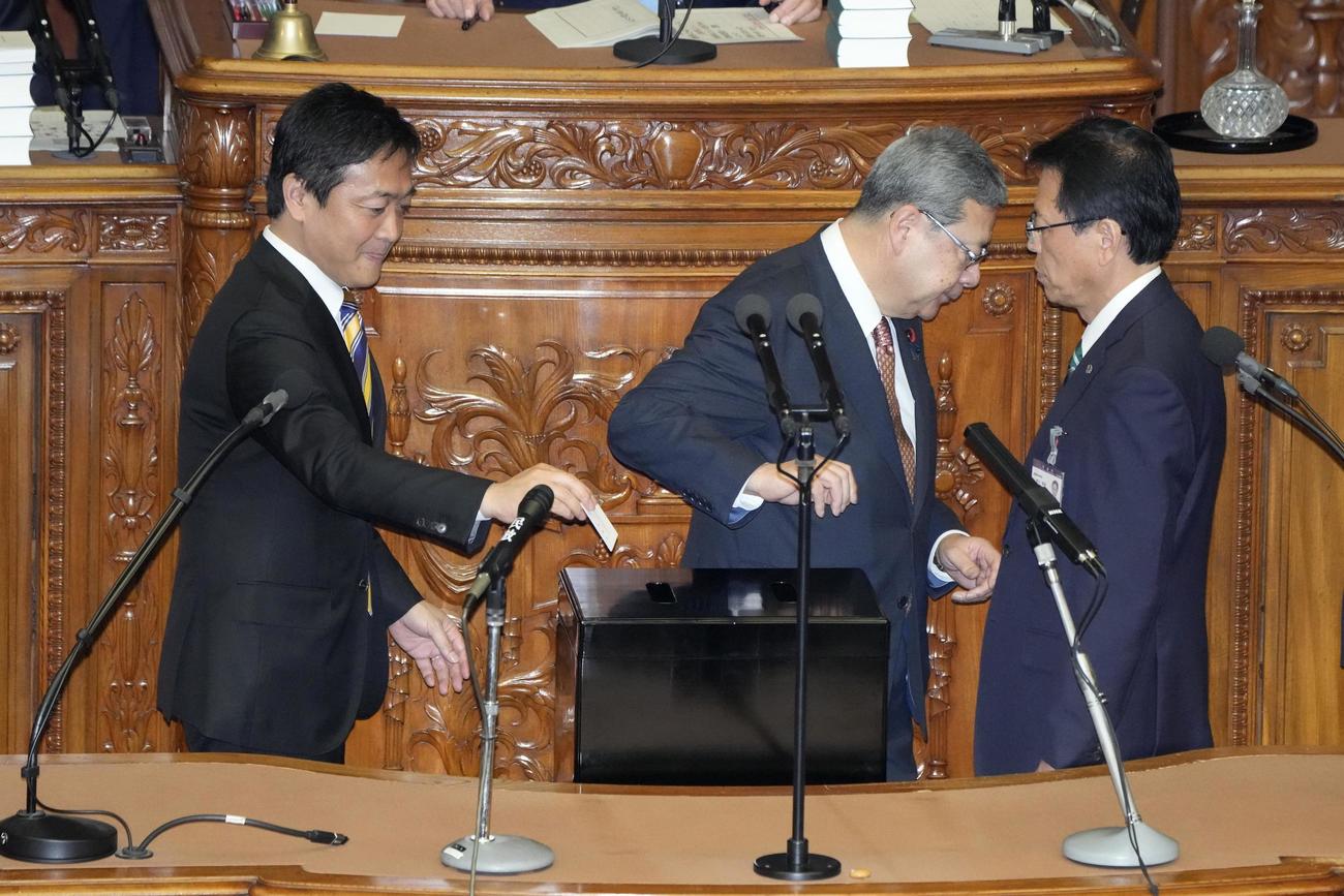 衆院本会議の首相指名選挙で投票する国民民主党の玉木雄一郎代表（左）（共同）