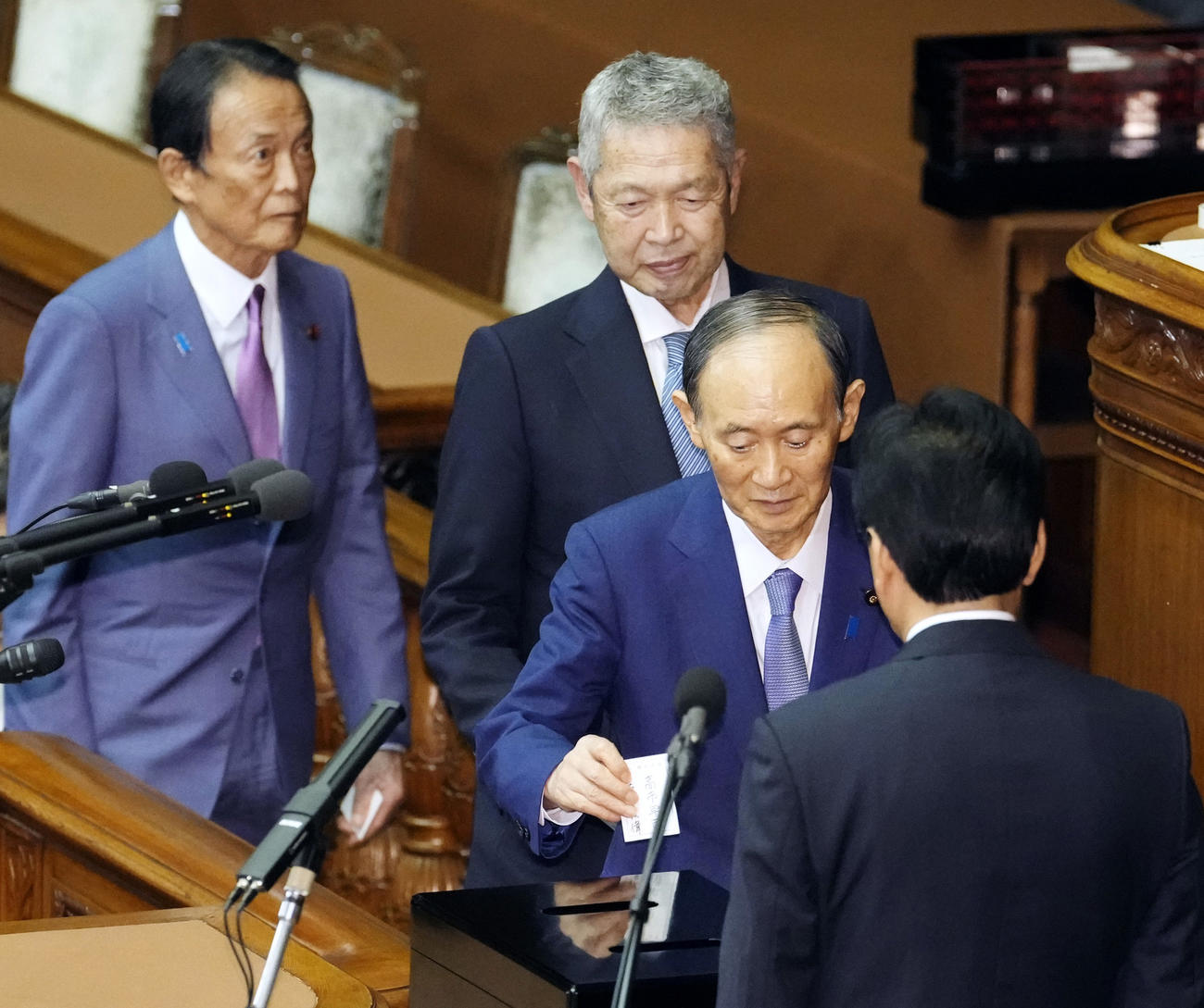 衆院本会議の首相指名選挙で投票する自民党の菅義偉元首相（手前）＝21日午後1時26分