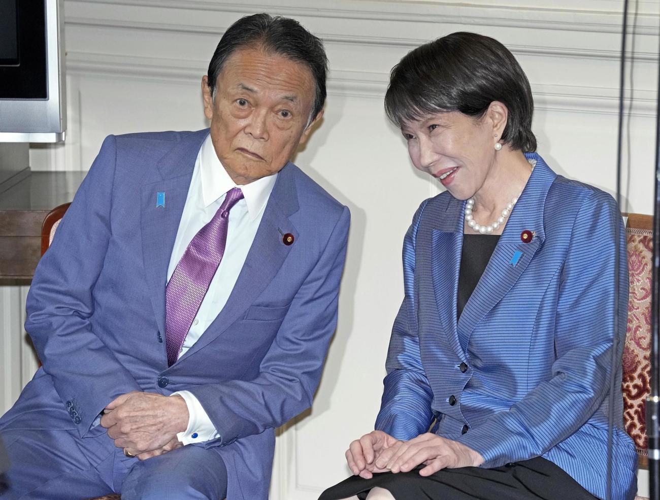 自民党の両院議員総会で麻生太郎副総裁（左）と話す高市早苗総裁（共同）