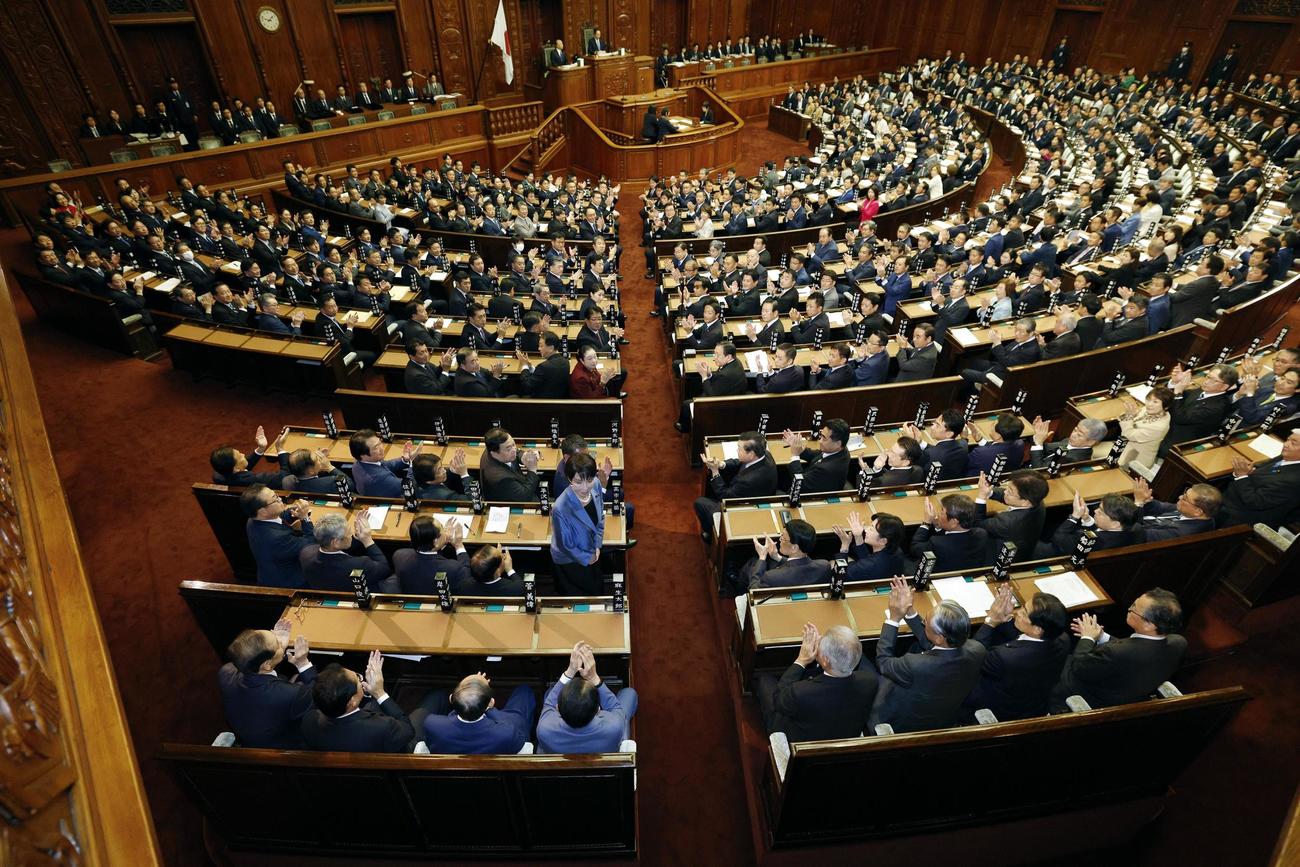 衆院本会議で第104代首相に指名され、拍手を受けながら起立する自民党の高市早苗総裁。憲政史上初となる女性首相が誕生した＝21日午後1時48分（共同）