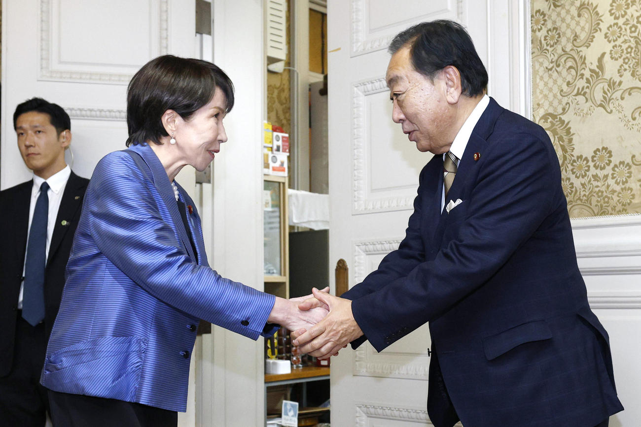 あいさつ回りで立憲民主党の野田佳彦代表（右）と握手する高市早苗首相（共同）