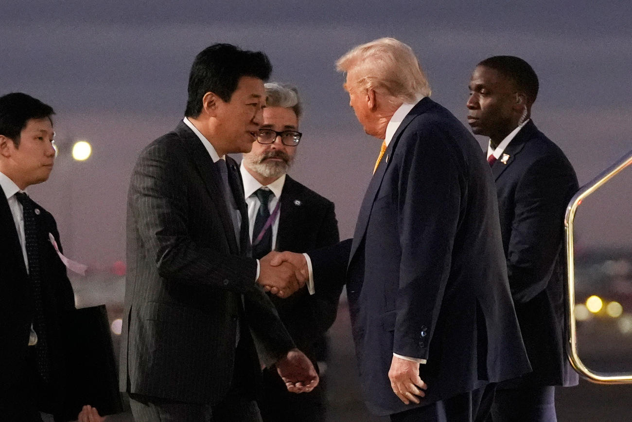 羽田空港でトランプ米大統領（右）を出迎える木原官房長官（AP＝共同）