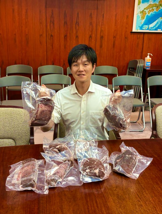 「強烈すぎる激励の差し入れ 」を手に笑顔の鈴木憲和農相（Xから）