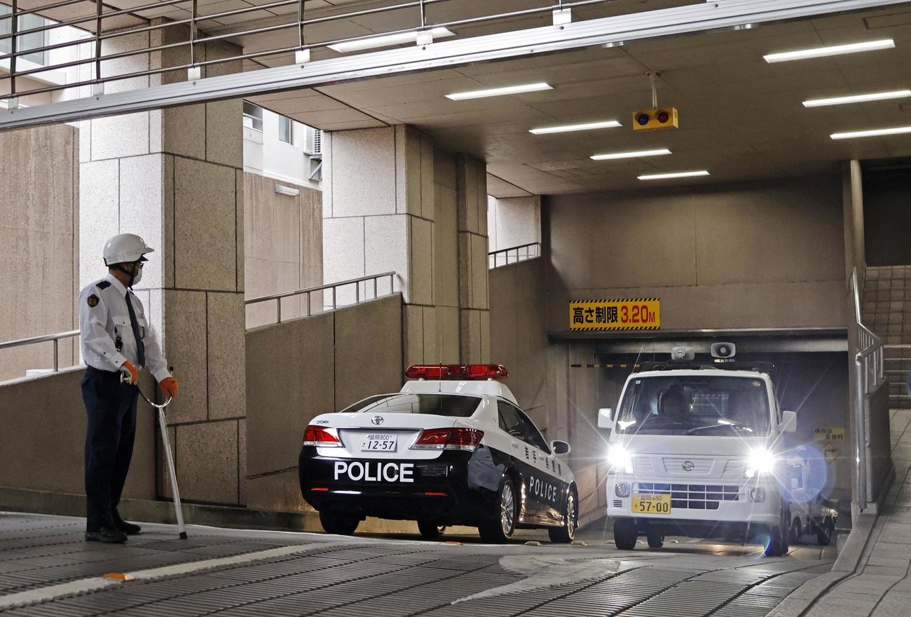 岩手銀行本店の地下駐車場から、捕獲されたクマを運び出す車両（右）（共同）