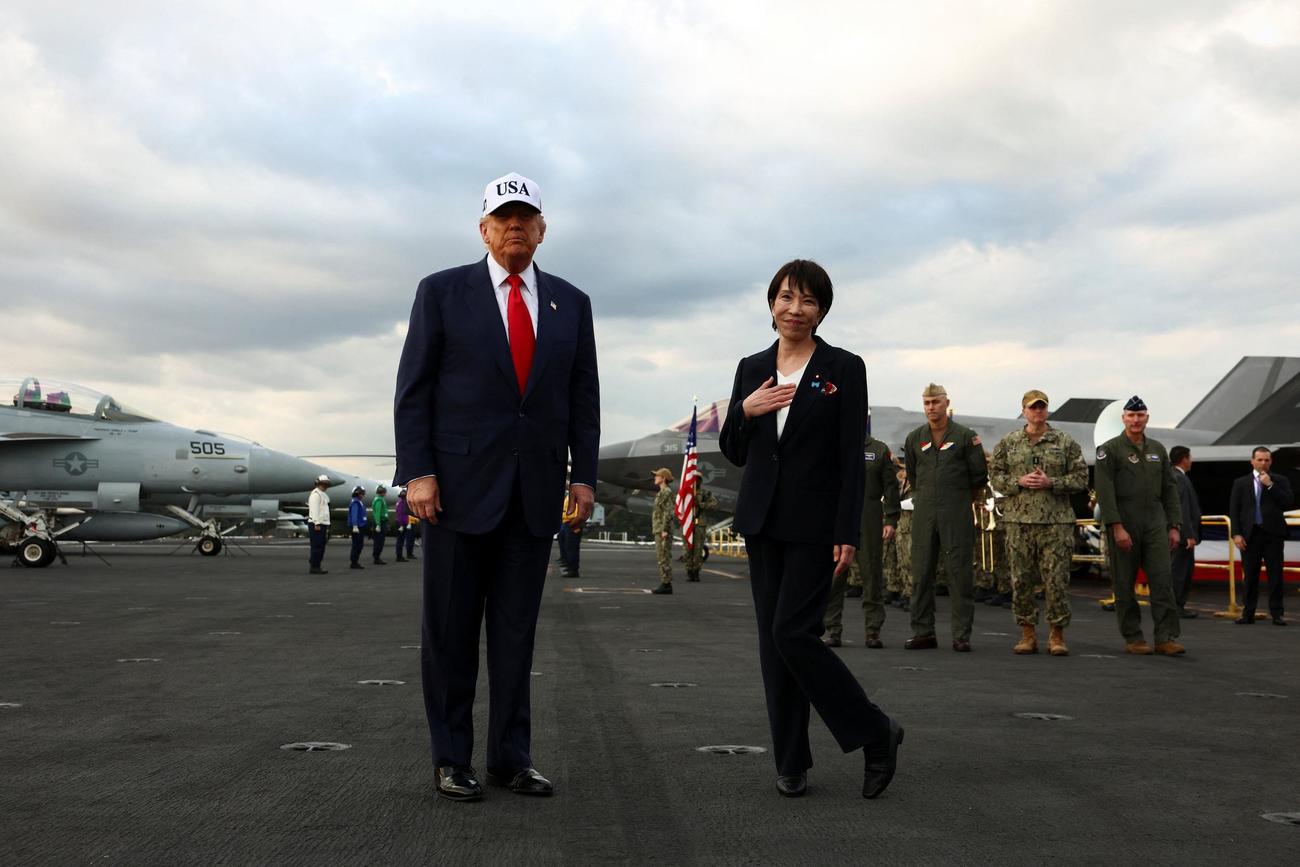 米原子力空母「ジョージ・ワシントン」に乗り込んだパンツスーツ姿の高市早苗首相（右）とトランプ米大統領（ロイター）