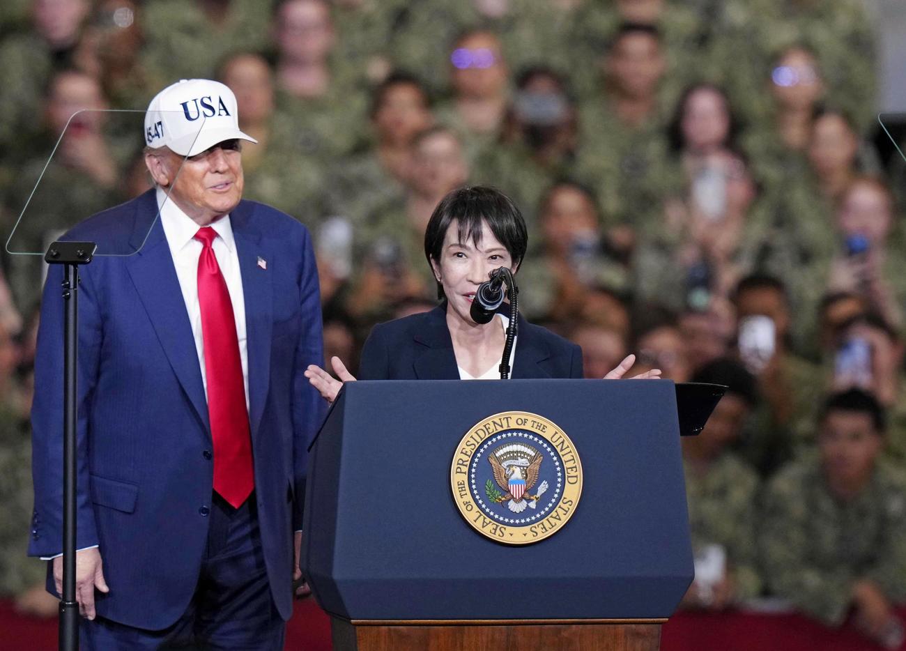 米海軍横須賀基地を訪問し、原子力空母ジョージ・ワシントン艦内で演説する高市首相。左はトランプ米大統領（共同）