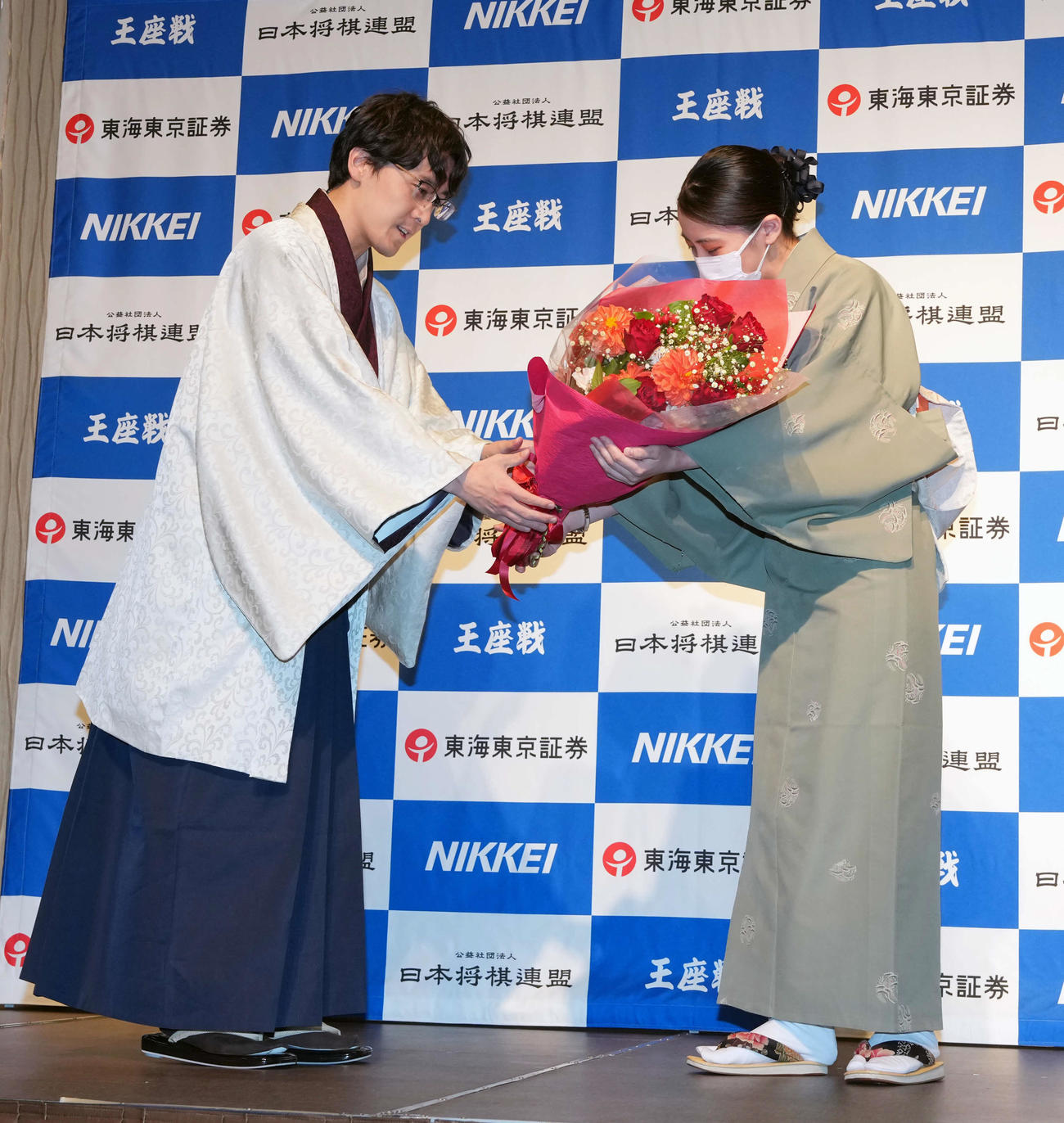 藤井聡太6冠を破り会見で花束を受け取る伊藤匠2冠（左）（撮影・小島史椰）
