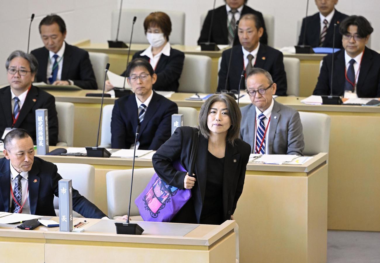静岡県伊東市議会臨時議会の議場に入り、着席する田久保真紀市長（手前右）（共同）