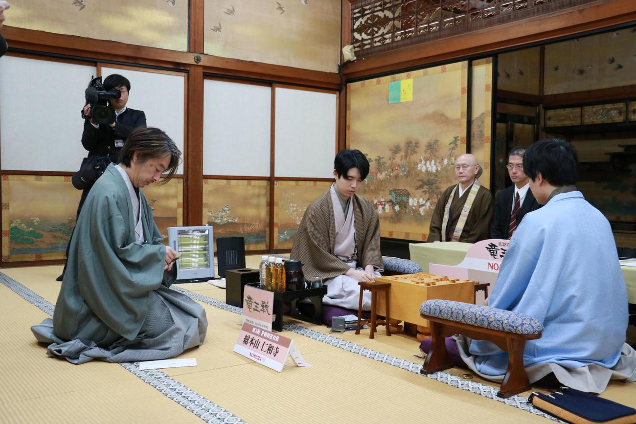 久保利明九段（左）の封じ手の開封を待つ佐々木勇気八段（右）藤井聡太竜王（中央）