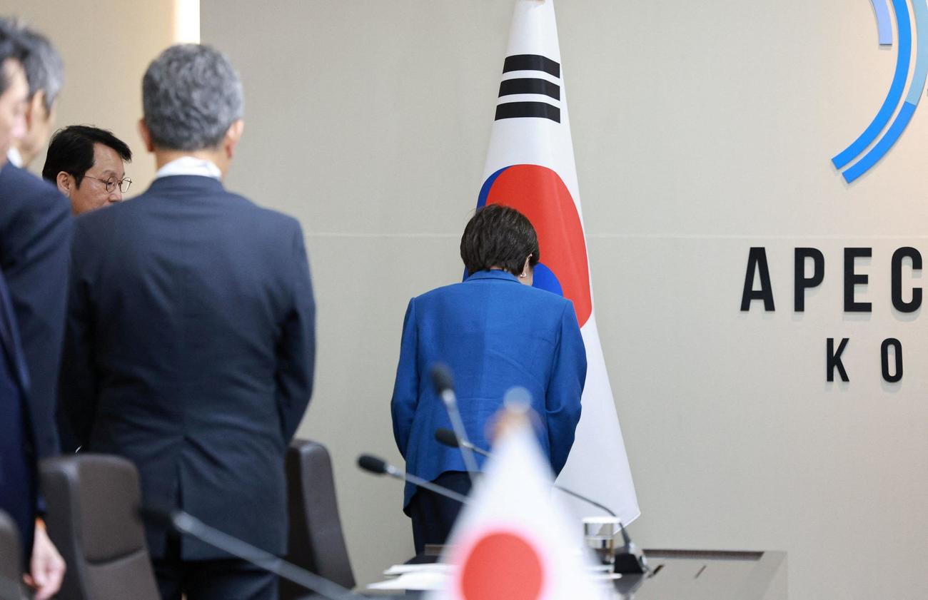 韓国国旗にお辞儀をする高市早苗首相（ロイター）