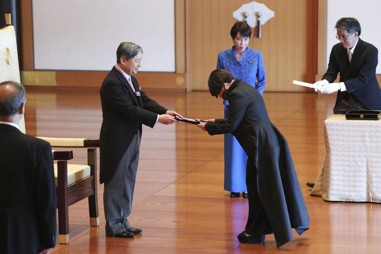 文化勲章の親授式で、天皇陛下から勲章を受けるデザインのコシノジュンコさん（代表撮影）