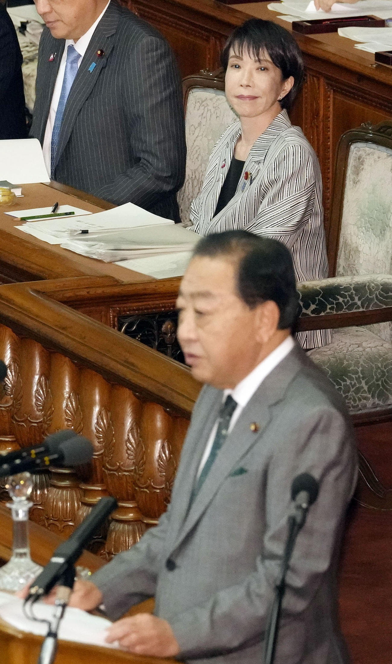 衆院本会議で立憲民主党の野田代表の質問を聞く高市首相（奥）（共同）