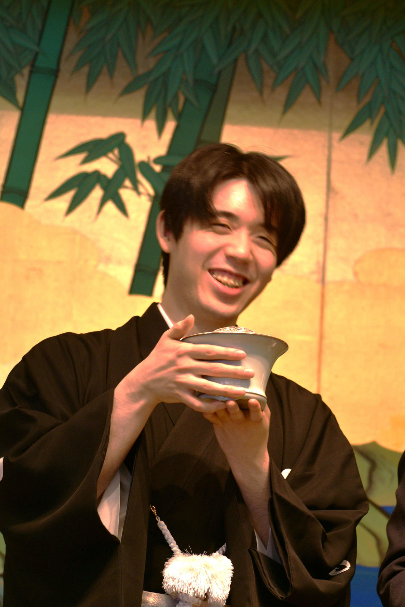 記念品として贈呈された人間国宝の陶芸家・福島善三氏作の「中野月白瓷香炉（なかのげっぱくじこうろ）」を手に笑顔を見せる藤井聡太王位