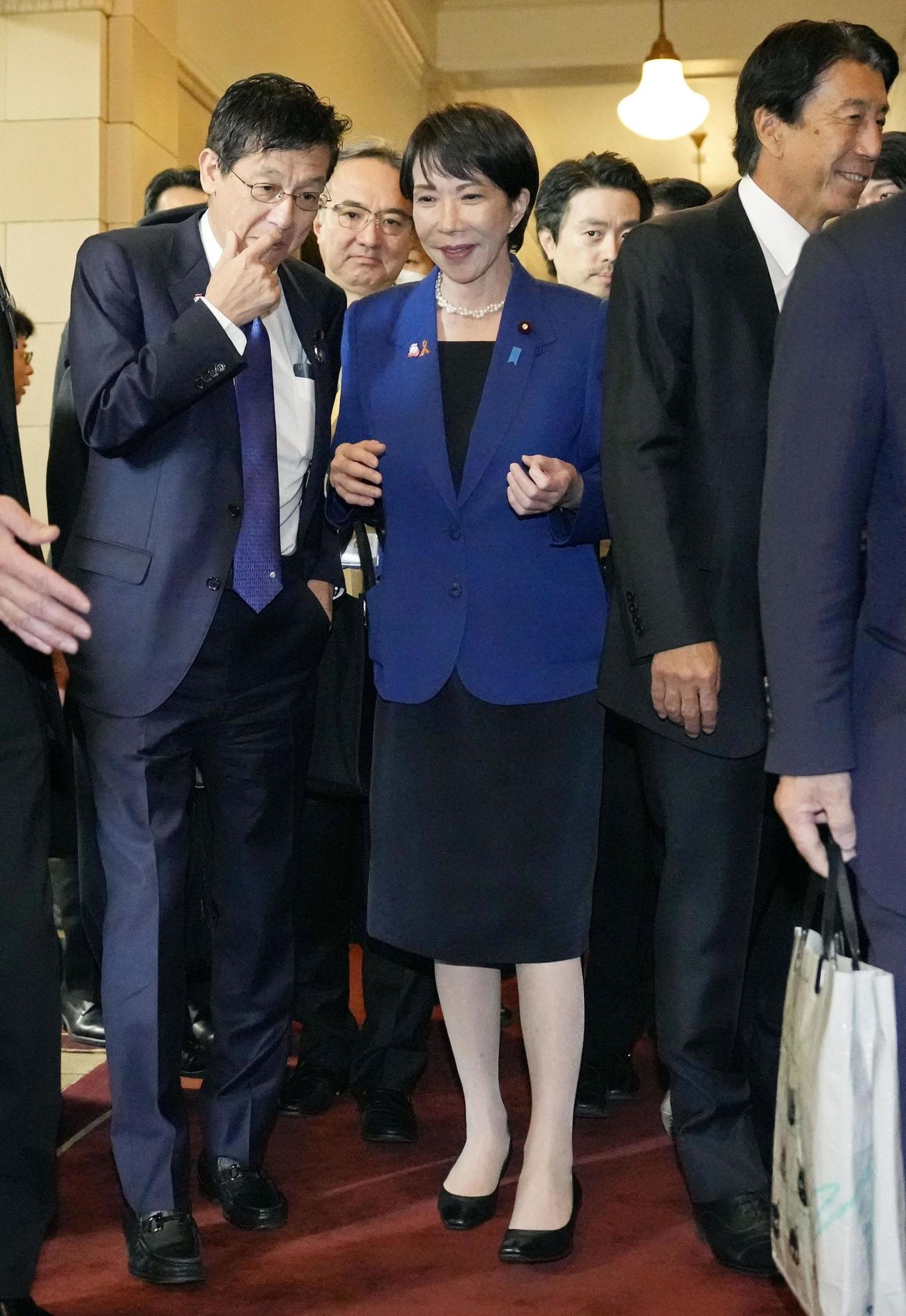 午前の衆院予算委を終え、松本デジタル相（左）と言葉を交わす高市首相（共同）