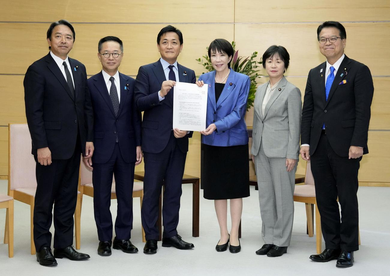 経済対策の策定に向けた国民民主党の提言を高市首相（中央右）に手渡す玉木代表（同左）＝12日午後、首相官邸（共同）