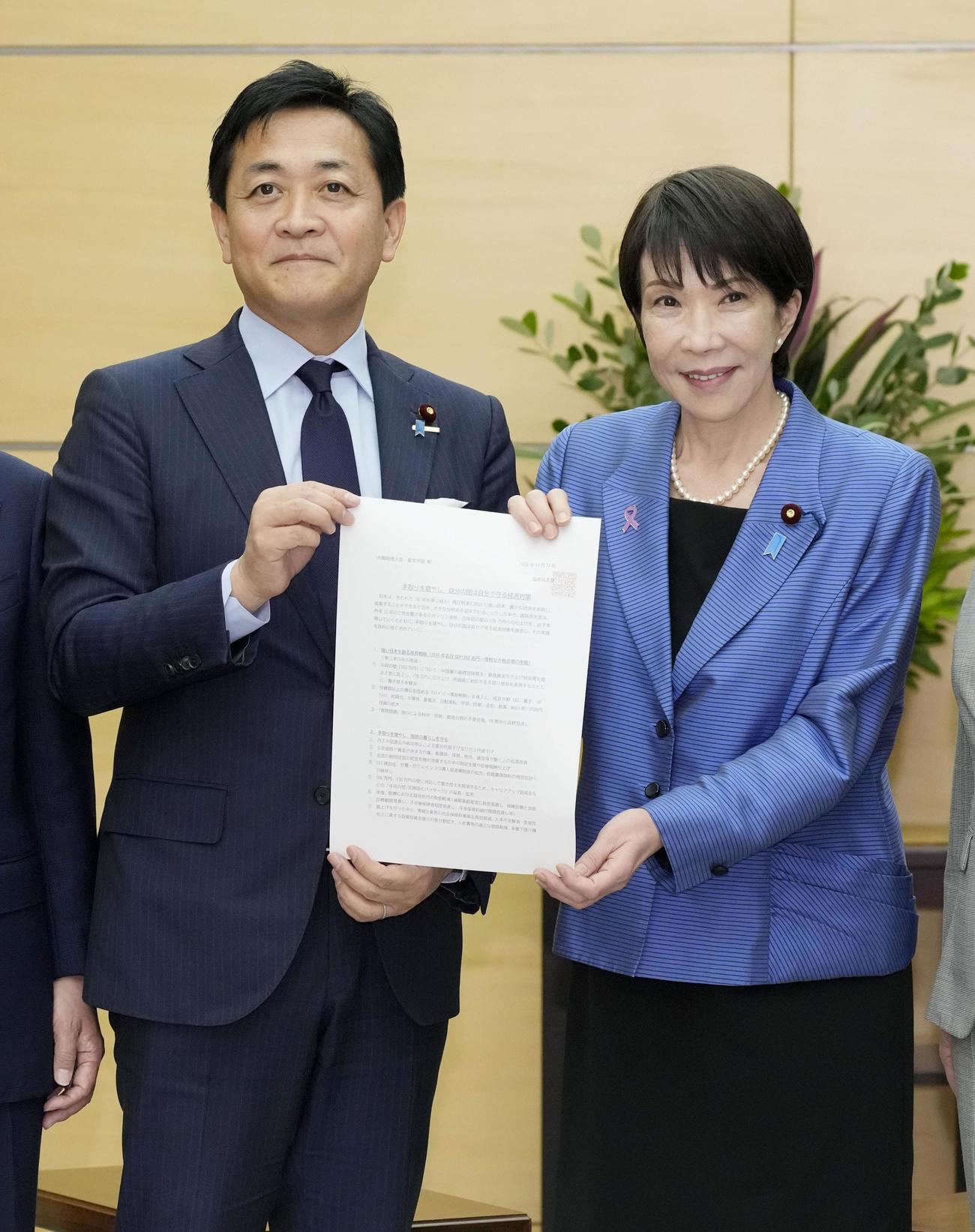 経済対策の策定に向けた国民民主党の提言を高市首相（右）に手渡す玉木代表（共同）