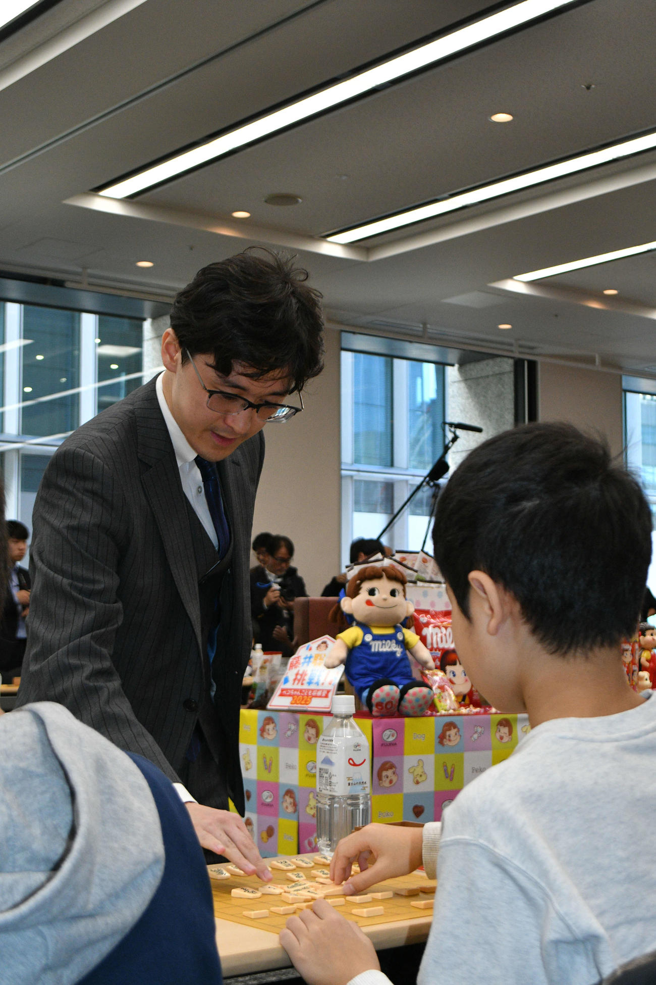 子どもたちに指導対局を行う伊藤匠2冠