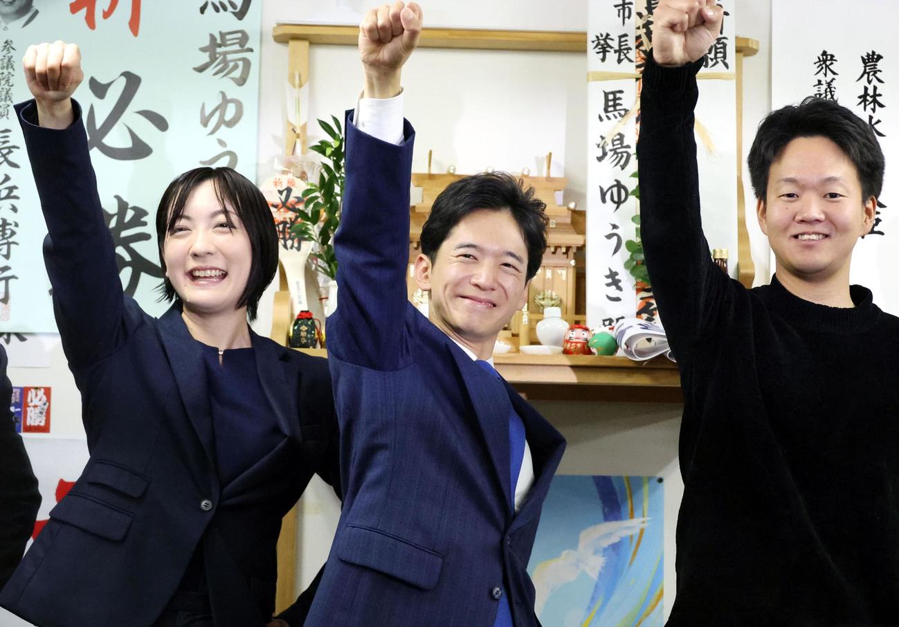 福島市長選で初当選を決め、こぶしを突き上げる馬場雄基氏（中央）＝16日夜、福島市（共同）