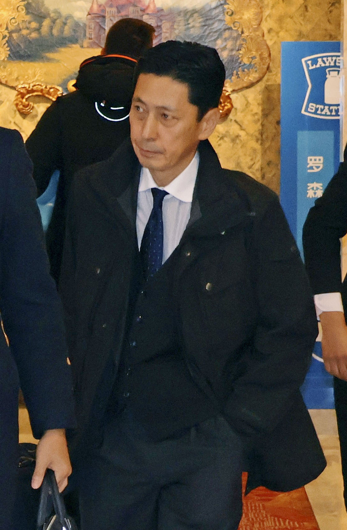 18日、宿泊先のホテルを出発する外務省の金井正彰アジア大洋州局長（共同）