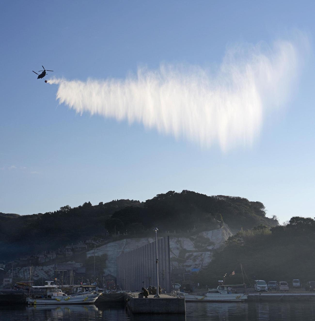 大分市佐賀関の大規模火災現場付近で上空から放水する自衛隊のヘリコプター（共同）