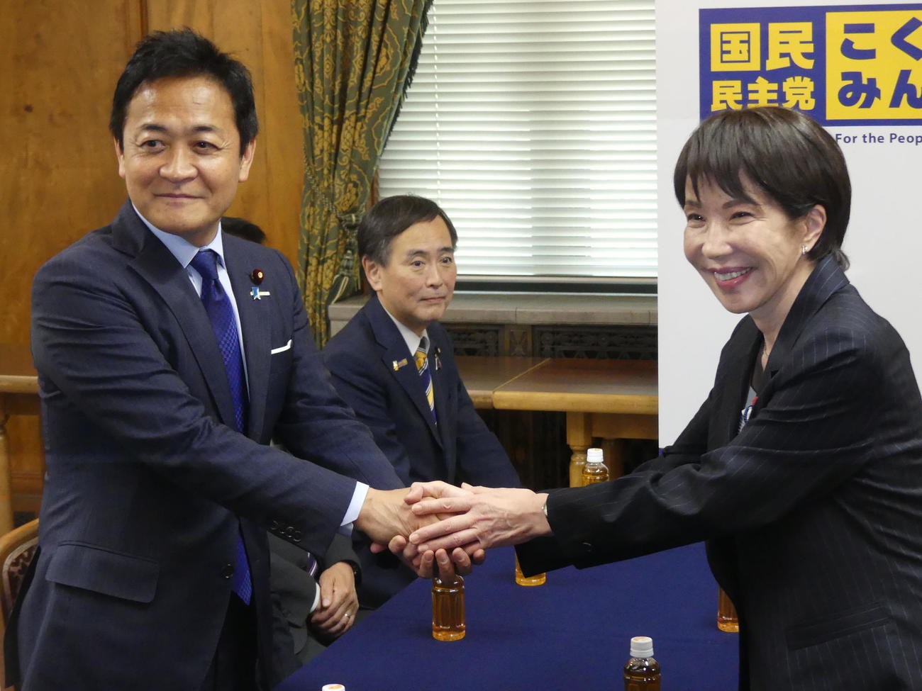 国民民主党の玉木雄一郎代表（左）と握手をかわす自民党の高市早苗総裁（2025年10月撮影）