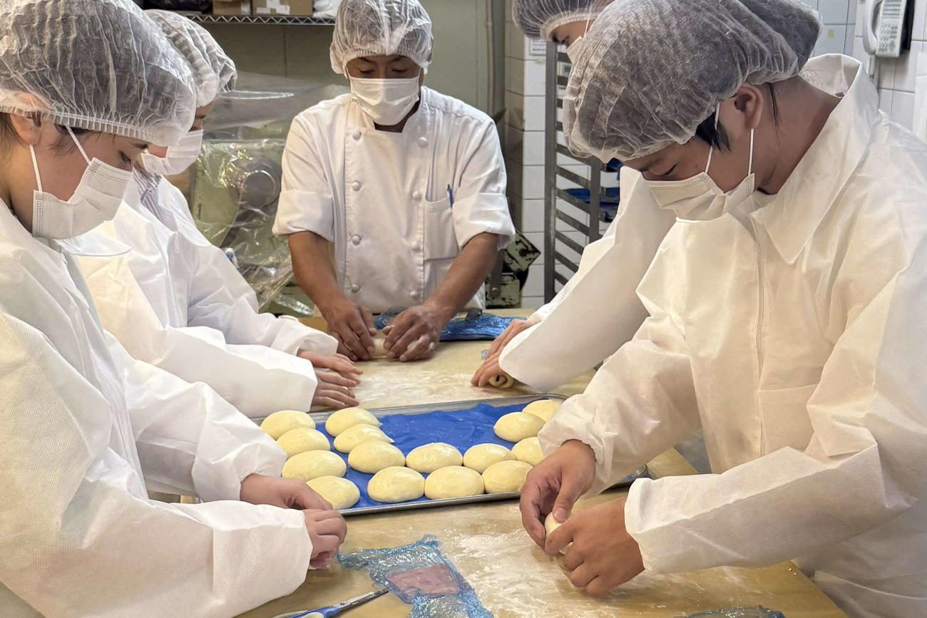 「みたらしコッペ」の商品化に向けてN高グループとN中等部の生徒たちは実際にパン生地を練る作業などを体験