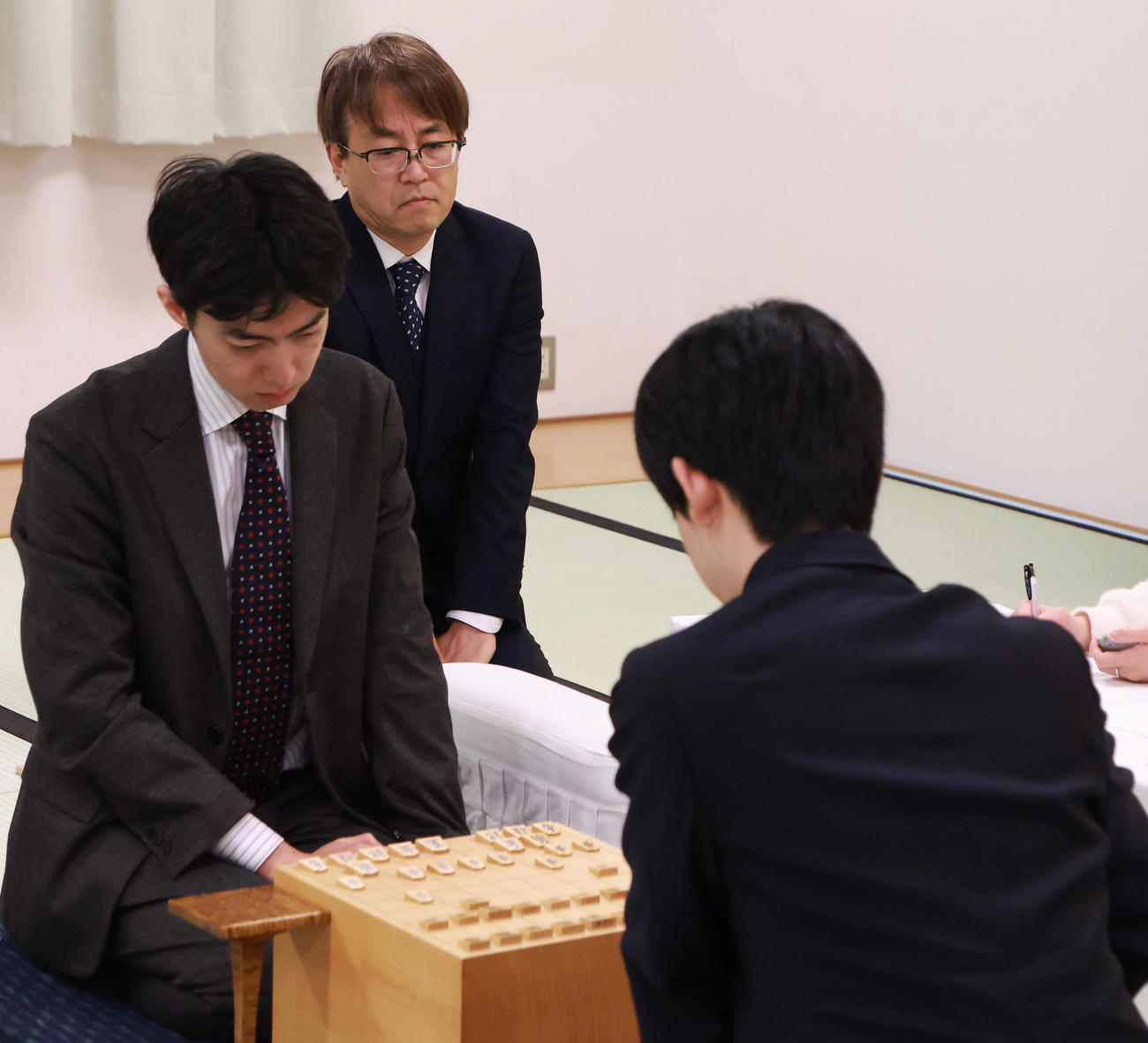 リレー将棋で藤井聡太6冠（右）を見つめる羽生善治九段。左は中村太地八段（撮影・中島郁夫）