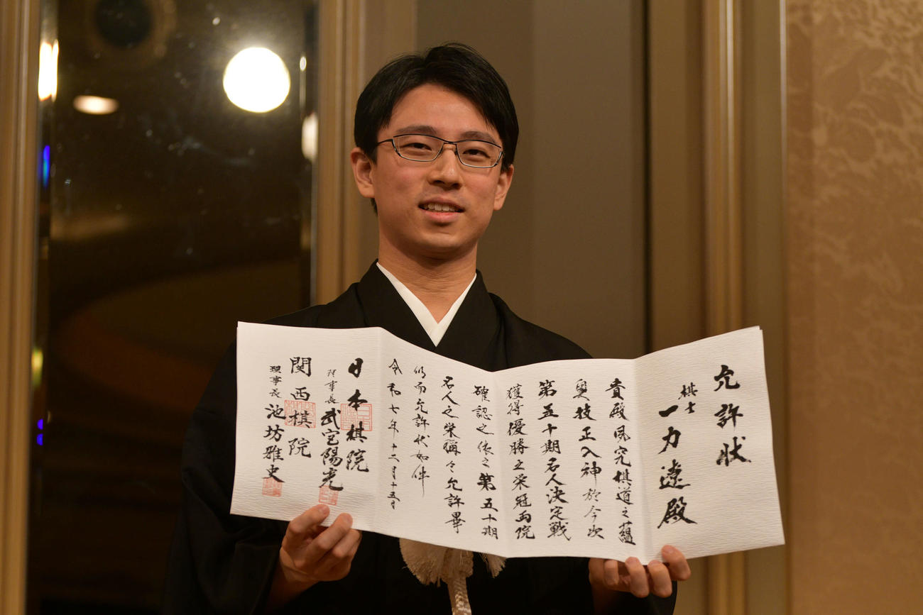 就位式で允許（いんきょ）状を手にする一力遼名人