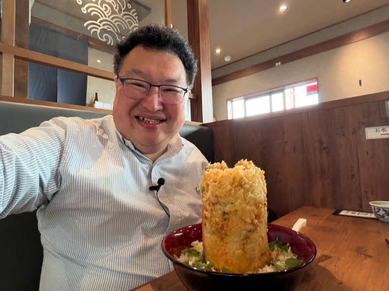 沼津「御膳屋丸天」で、名物の「海鮮かき揚げ丼」を前に笑顔の鳥海氏（提供：鳥海高太朗氏）