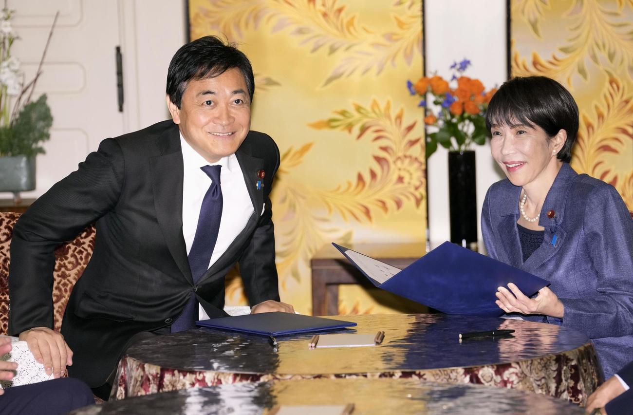 「年収の壁」を巡る合意書に署名し、笑顔を見せる高市首相（右）と国民民主党の玉木代表＝18日（共同）