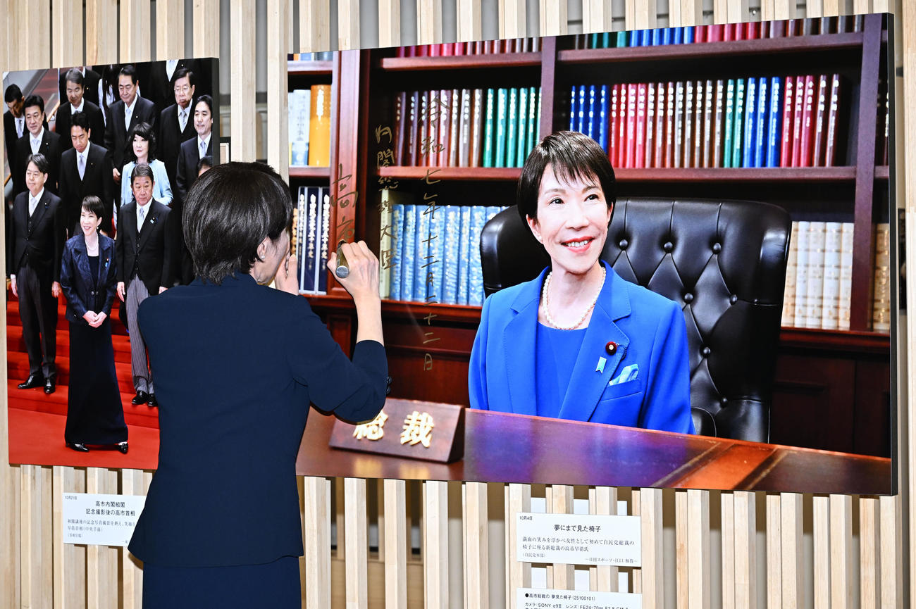 「2025年報道写真展」で本紙・江口和貴カメラマンが撮影した自身の写真にサインする高市首相（撮影・千葉一成）