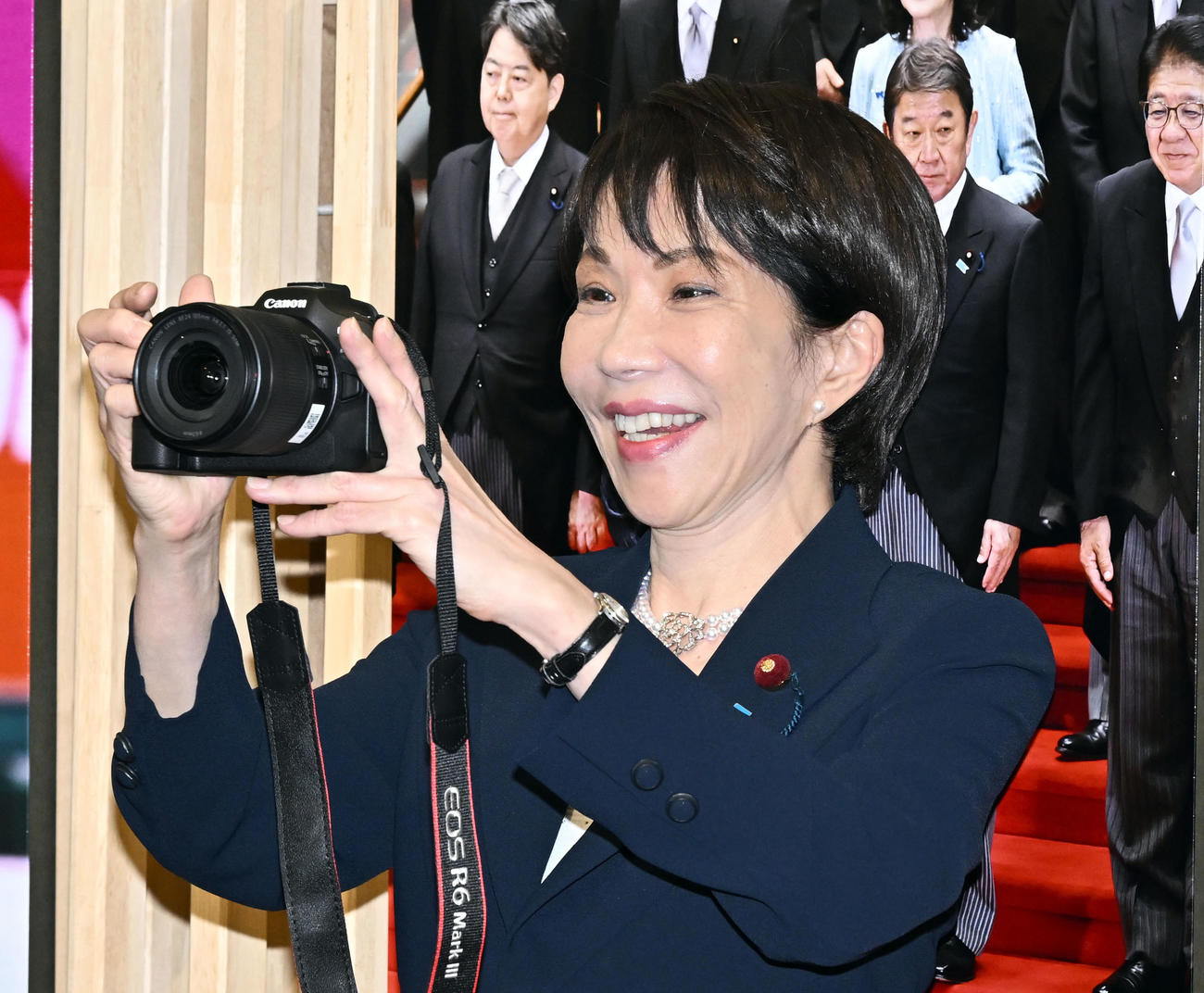 「2025年報道写真展」で手渡されたカメラで報道陣の写真を撮る高市首相（撮影・千葉一成）