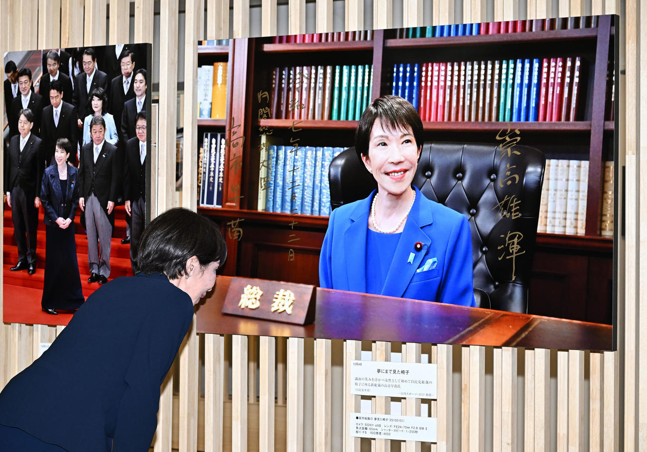 「2025年報道写真展」で本紙・江口和貴カメラマンが撮影した自民党総裁の椅子に座る自身の写真にサインした高市首相（撮影・千葉一成）