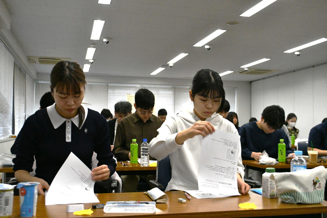 詰碁王決定戦の東京会場で問題を解く姉の上野愛咲美女流名人（左）と妹の上野梨紗女流棋聖（右）