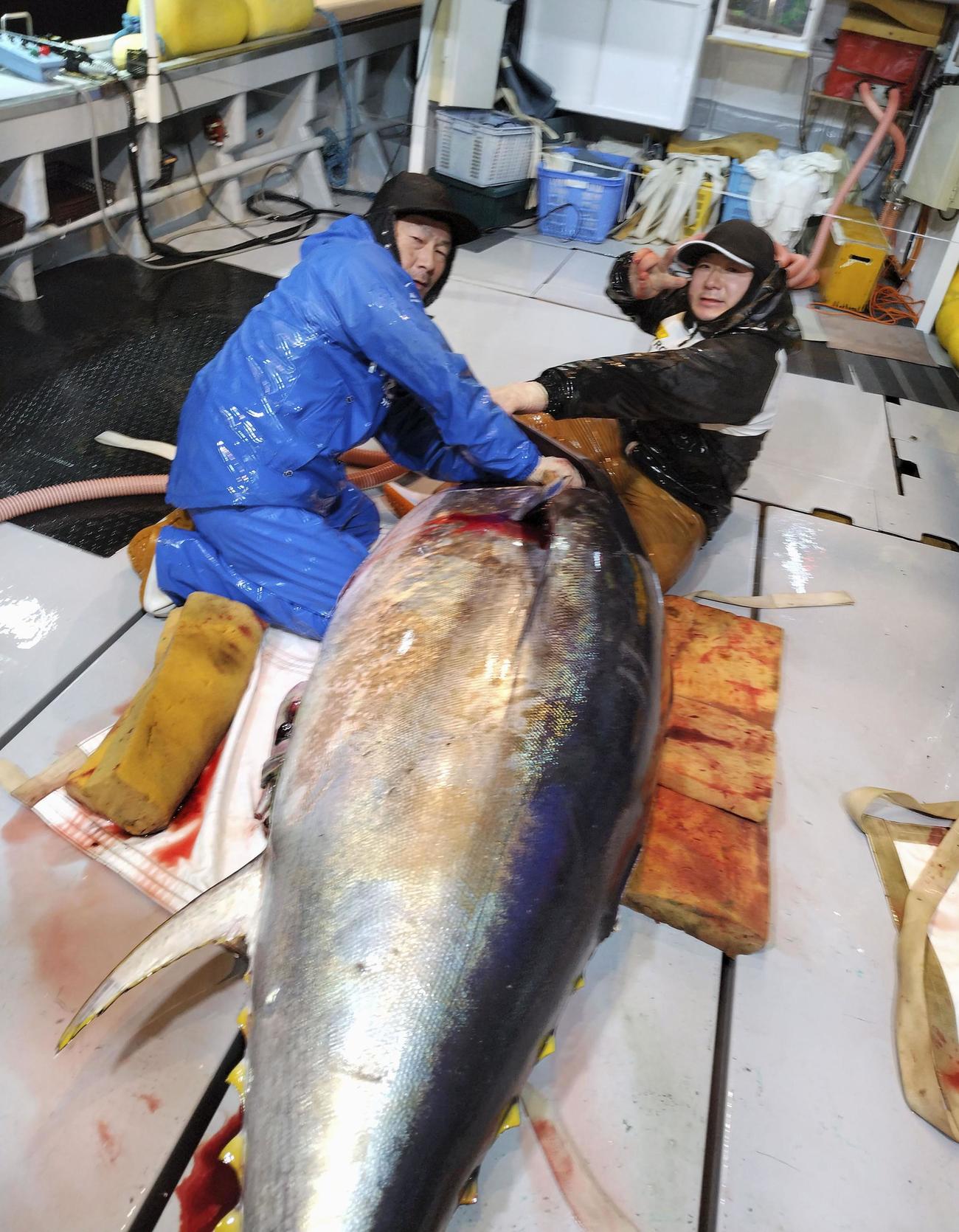 初競りで5億1030万円の最高値が付いたクロマグロと写真に納まる、伊藤豊一さんの弟喜博さん（左）と長男一長さん＝青森県大間町沖（豊一さん提供）