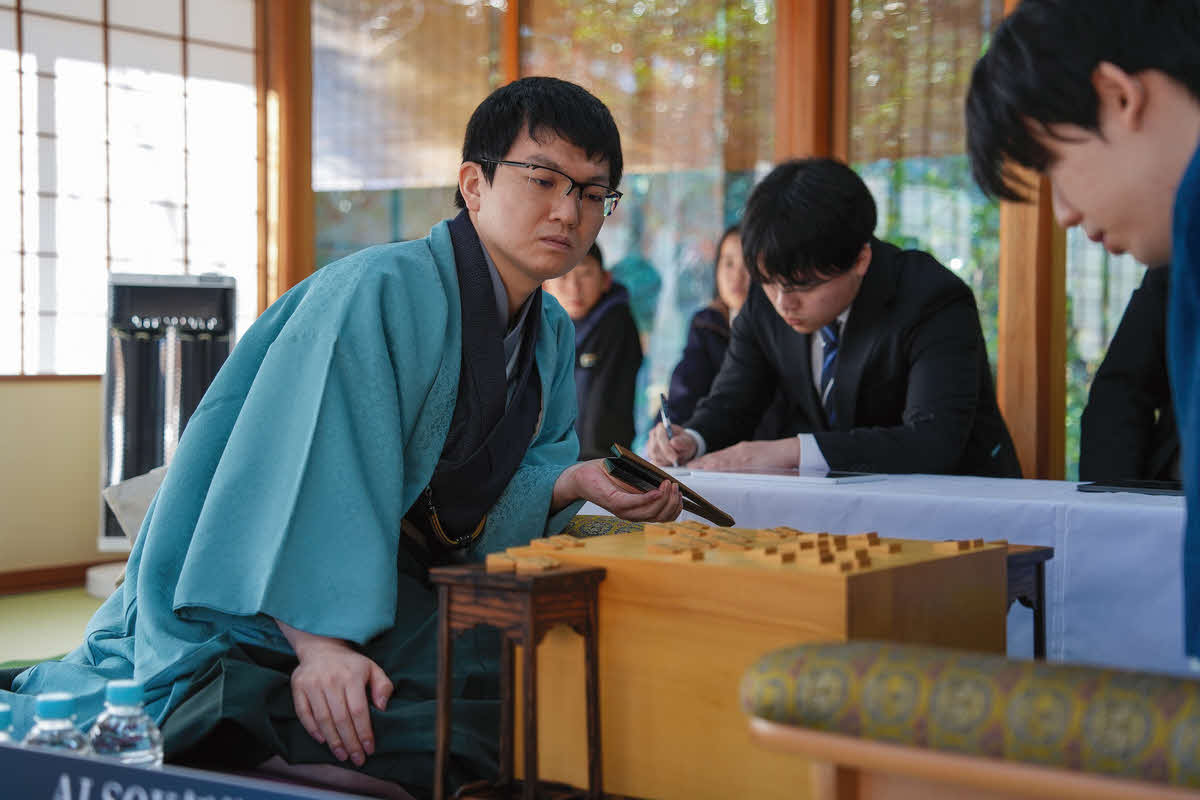初日から攻勢を仕掛けて開幕戦勝利を目指す永瀬拓矢九段（左、右は藤井聡太王将＝日本将棋連盟提供）