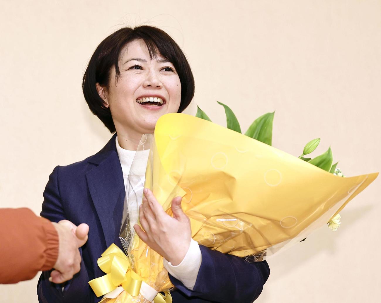 前橋市長選で再選を決め、花束を手にする小川晶氏＝12日夜、前橋市（共同）