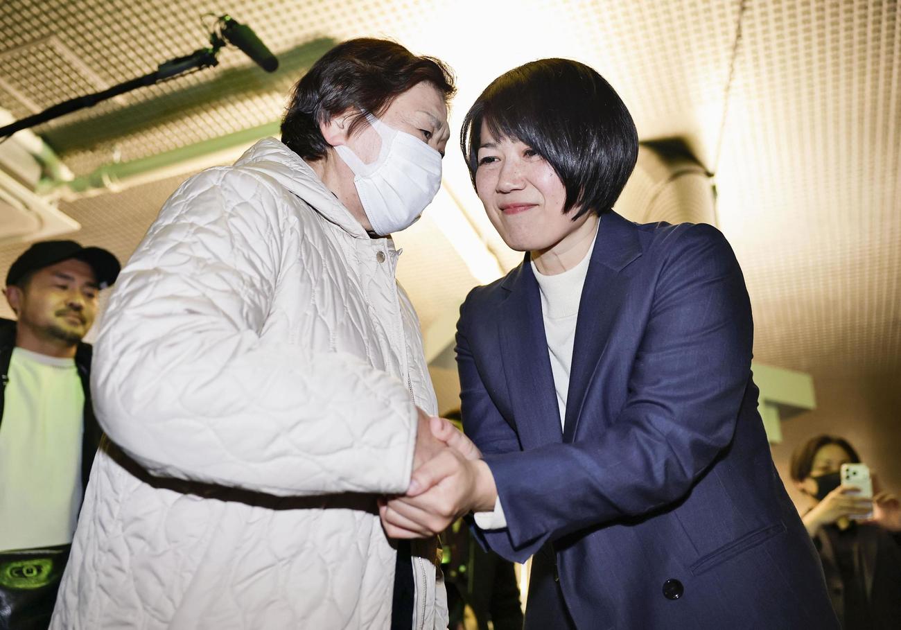 前橋市長選で再選を決め、支持者と握手する小川晶氏（右）（共同）
